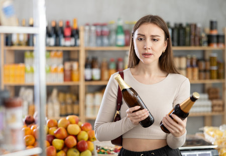 Young woman choosing beer in grocery storeの写真素材