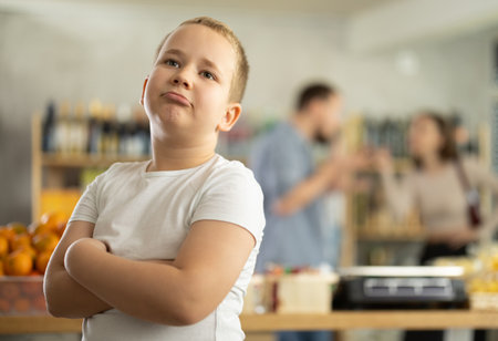 Unhappy boy during parents quarrel in grocery storeの写真素材