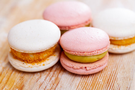 Delicate vanilla french macaroons close-up on wooden tableの写真素材