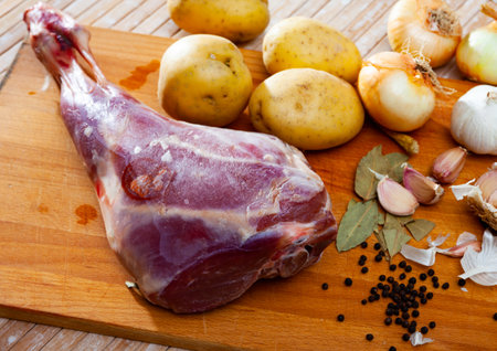 Raw lamb leg with natural ingredients before cookingの写真素材