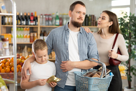 Young family with little son choosing products in supermarketの写真素材