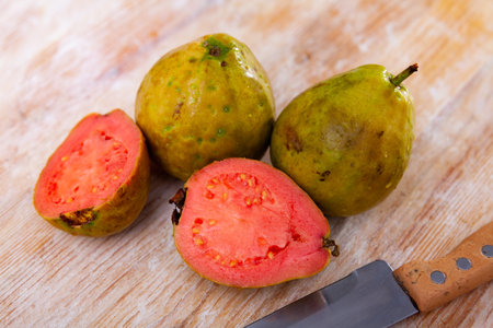 Fresh whole and sliced guava fruits on wooden tableの写真素材