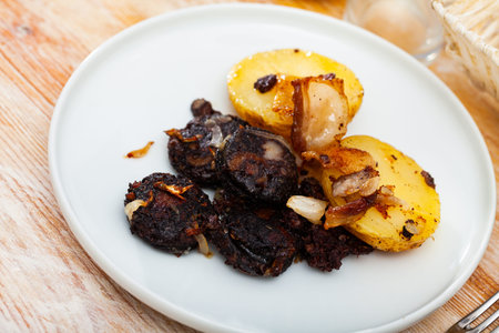 Blood sausages served with potato and onion