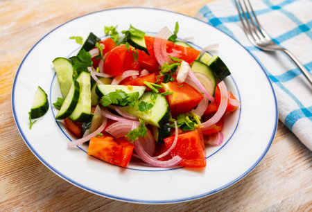 Salad with fresh tomatoes, cucumbers, red onion and herbsの写真素材