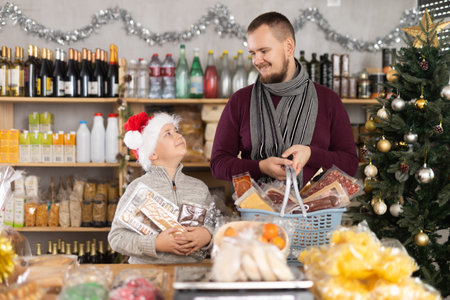 Young man with son choosing products in grocery storeの写真素材