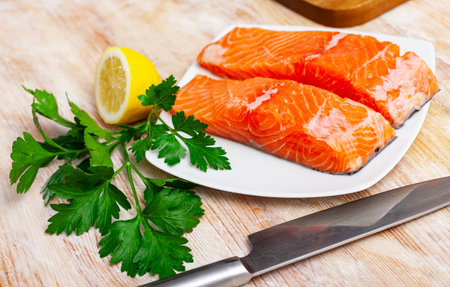 Raw salmon fillet with lemon and greens before cookingの写真素材