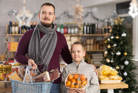 Man and boy choose tangerines in grocery storeの写真素材