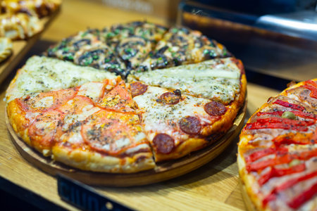 Fresh baked pizza from several slices of different pizza flavorsの写真素材