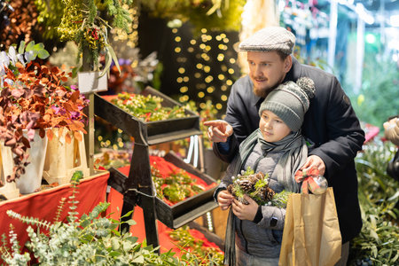 Man and his son choose plant branches for decorationの写真素材