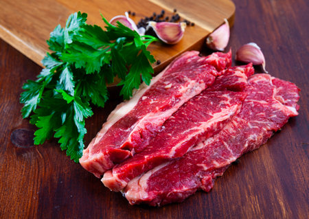 Raw sliced marbled beef meat with parsley and condimentsの写真素材
