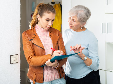 Senior and younger women filling rent contractの写真素材