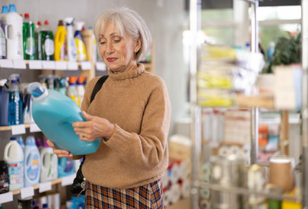 Mature woman choosing laundry detergent in department storeの写真素材