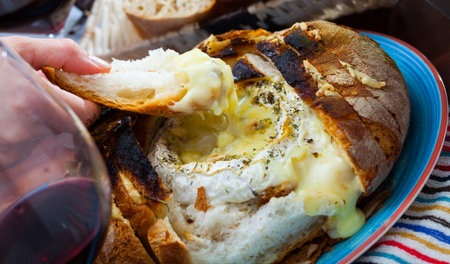 Dish of french cuisine, fresh bread with melted camembert cheese