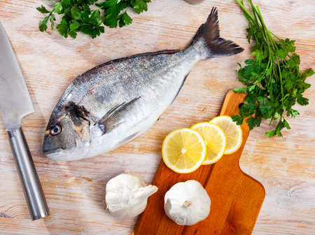 Whole dorado fish on wooden surfaceの写真素材