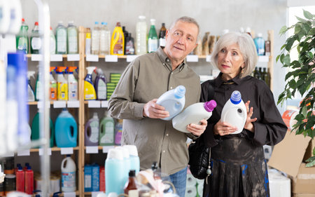 Married couple choose detergent together in supermarketの写真素材