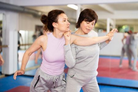 Female pupil clash with training manager during self-defense lesson, repulse charge, intensity of...