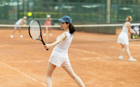 Woman playing tennis against female opponent on tennis courtの写真素材