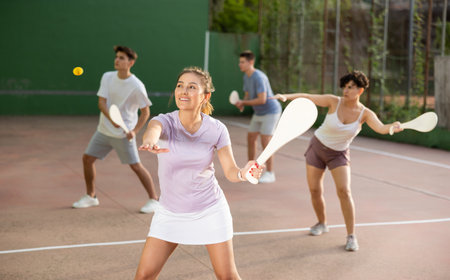 Woman serving ball during frontenis game outdoorsの写真素材