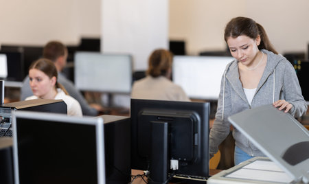 Young woman scanning documents in office