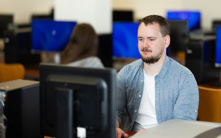 Portrait of concentrated man during lesson in computer room of school computer class