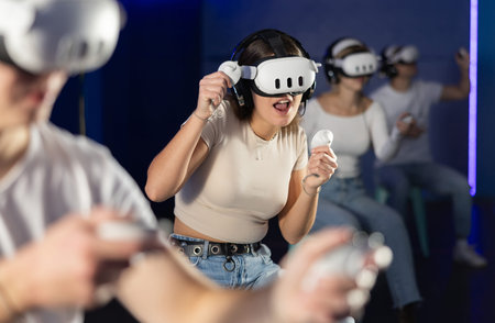 Girl in vr glasses with joysticks playing a video game