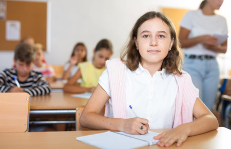 Portrait of school girl who writing exercises at lesson in school