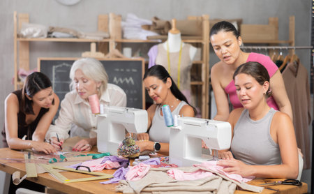 Group of women sew and draw pattern at sewing workshopの写真素材