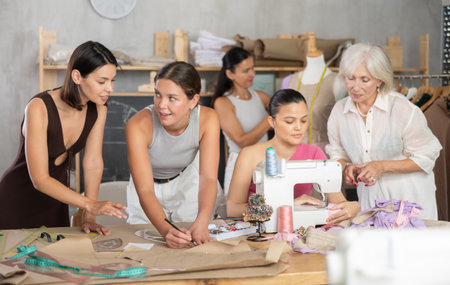 Group of women sew, draw pattern and work with mannequinの写真素材