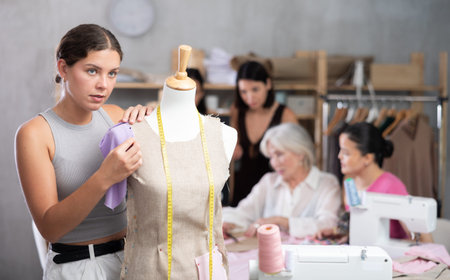 Young woman working with mannequin in workshop