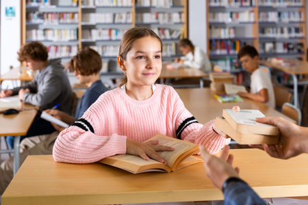 Girl giving books to librarian