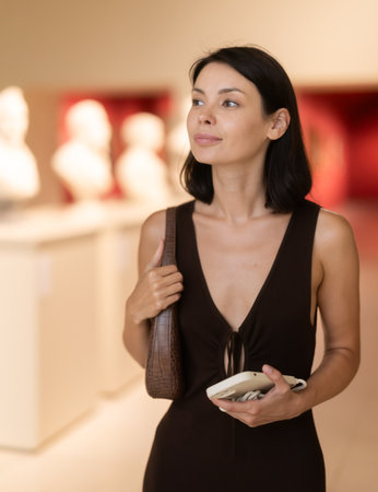 Brunette visits the halls of the museum with interestの写真素材