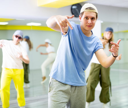 Young guy dancing modern dance in studio