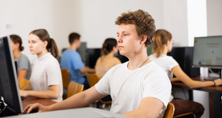 Schoolboy working with computers in classroom
