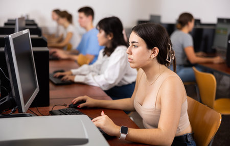 Focused Latin female teenager solving tasks of computer science in the auditory