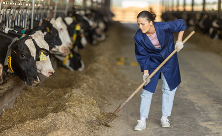 Middle-aged female farmer working with pitchforkの写真素材