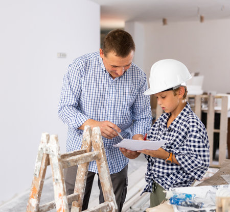 Man showing son blueprints in new homeの写真素材
