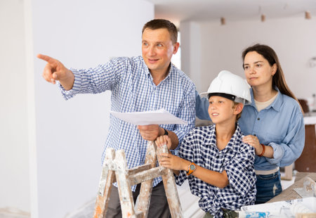 Parents and young son discussing work plan in construction site