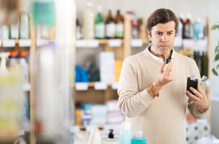 Man sniffs fragrance of perfume, chooses scent spray with pleasant smell