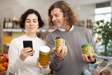 Couple get acquainted with food, scan QR code, take reading olives label using phone cameraの写真素材