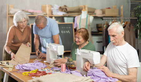 Elderly participants in sewing coterie learn sewing, communicate and talking, sewing, cut fabric by scissorsの写真素材