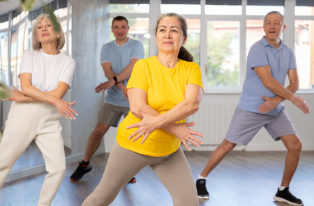 Group of aged people rehearsing sports dance in dance class