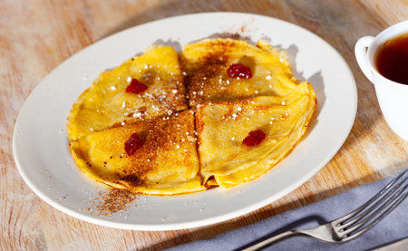 Crepes with cocoa and confiture for breakfast