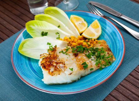Delicious fried cod fillet with endive, corn, and greens