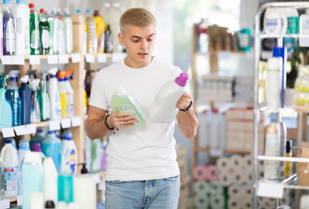 Male consumer with household chemical products for washing indoorsの写真素材