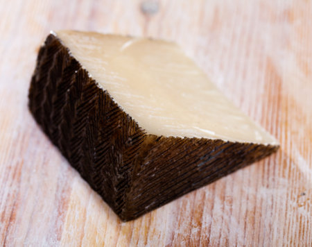 Spanish tasty sheep cheese Manchego on wooden surfaceの写真素材