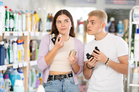 Young couple choosing perfume in department store