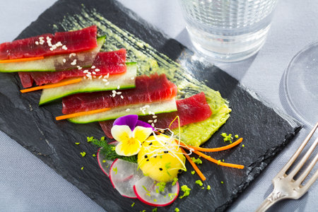 Raw tuna sashimi with cucumber and avocado sauceの写真素材
