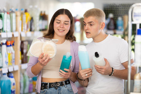 Couple man and woman choosing shampoo or shower gel and washclothの写真素材