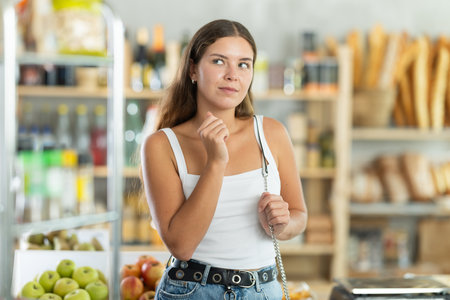 Female shopper chooses fresh produce in grocery supermarketの写真素材