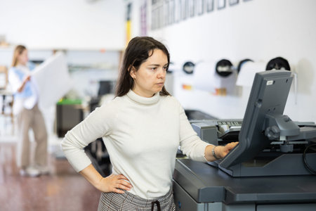 Woman working in printing office, using printer